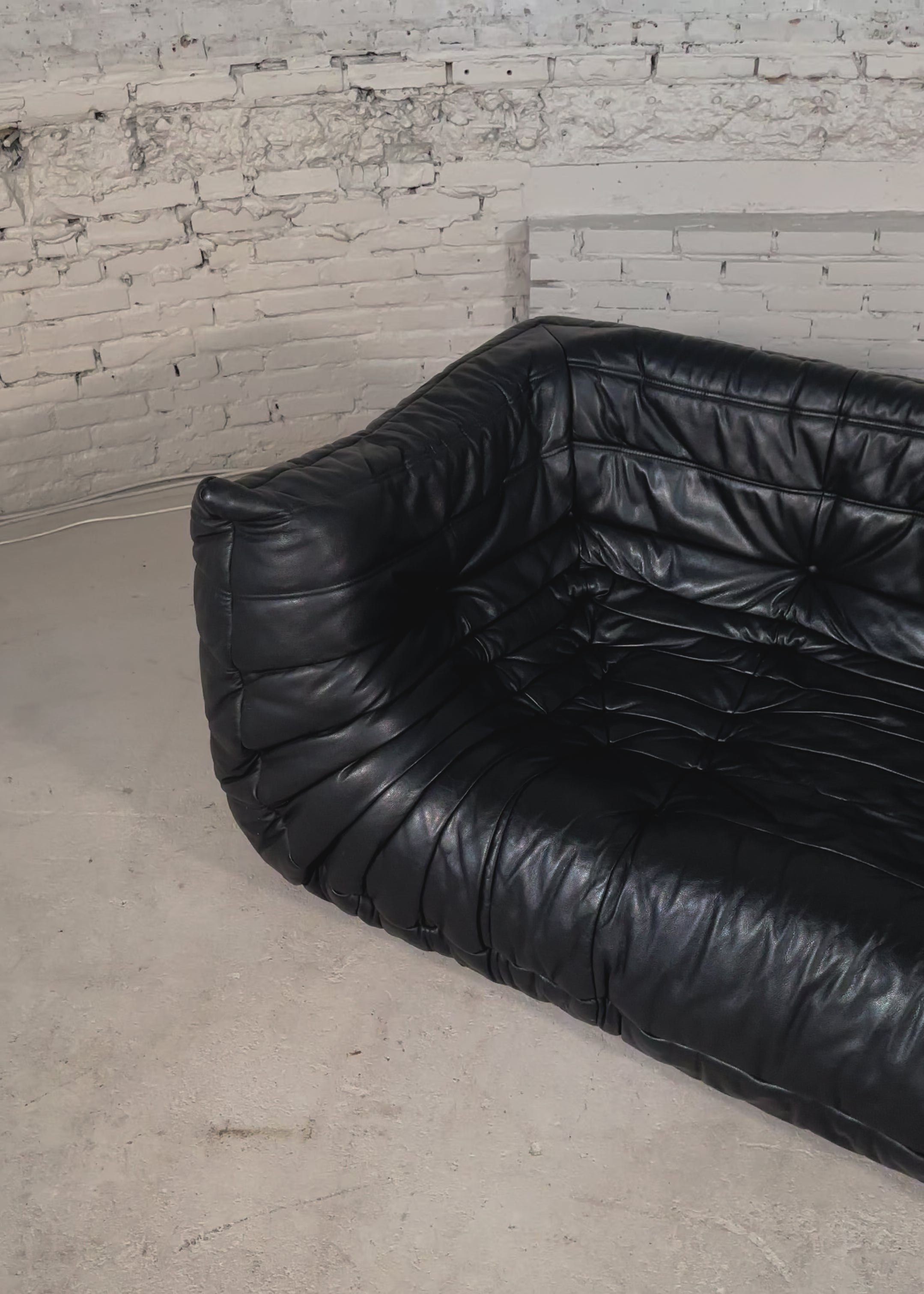 Load video: Ligne Roset medium Togo black leather